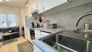 A modern kitchen with a stainless steel sink, a built-in oven, and a coffee maker. - Casa Angela by Ca-sa Check (Chioggia)