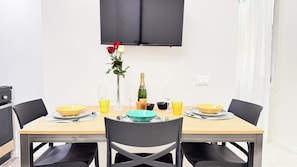 Una mesa de comedor dispuesta con varios cuencos, vasos y una botella de champán.