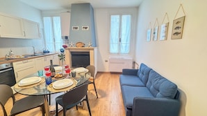 A compact kitchen with a dining area, a blue sofa, and a fireplace. - L'ultimo Venchero by Ca-sa Check (Chioggia)