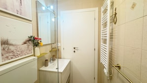 A bathroom with a white sink, a mirror, a towel rack, and a shower area. - L'ultimo Venchero by Ca-sa Check (Chioggia)