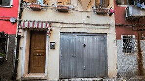 A narrow street with a closed metal door and a small window with metal bars. - Casa Andrea by Ca-sa Check (Chioggia)
