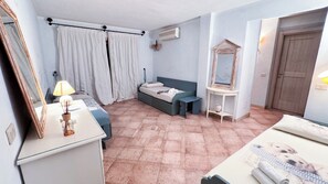 Habitación de hotel con cama, escritorio, silla, espejo y armario.