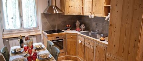 A kitchen with wooden cabinets, a stove, and a sink.