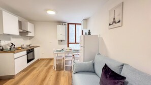A compact apartment with a kitchenette, dining area, and a living space with a couch and a window. - La Casa di Clelia by Ca-sa Check (Chioggia)