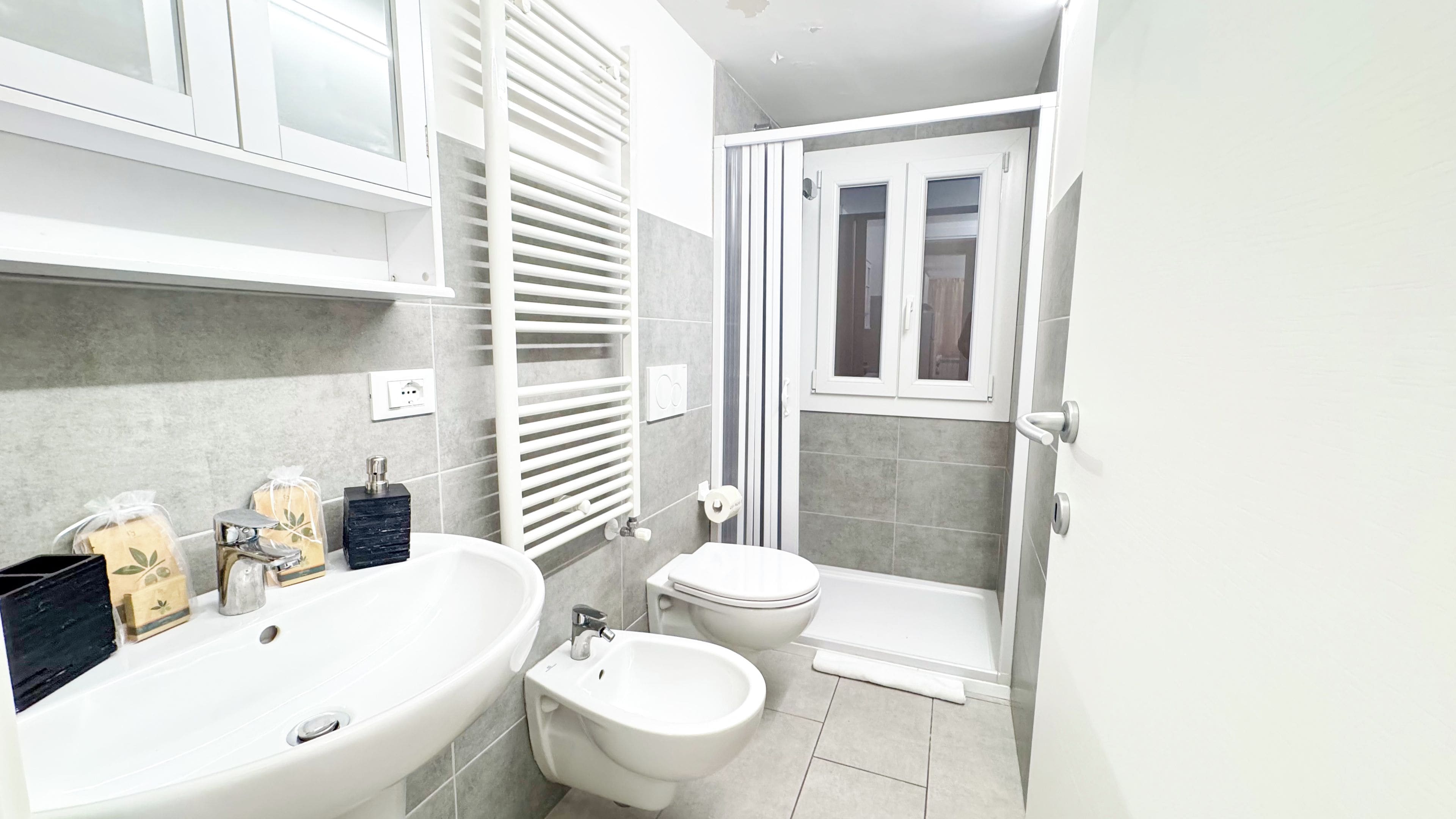 A modern bathroom with a bathtub, bidet, toilet, and a shower area.