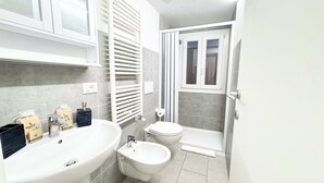 Un baño moderno con bañera, bidé, inodoro y zona de ducha.
