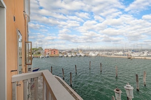 Un puerto deportivo con barcos amarrados, cielo despejado y edificios al fondo.