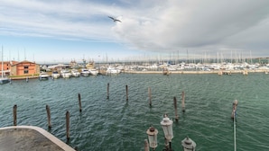 Marina com barcos atracados, estacas de madeira na água e um prédio com a inscrição 'CARRERA DE SALZON'.