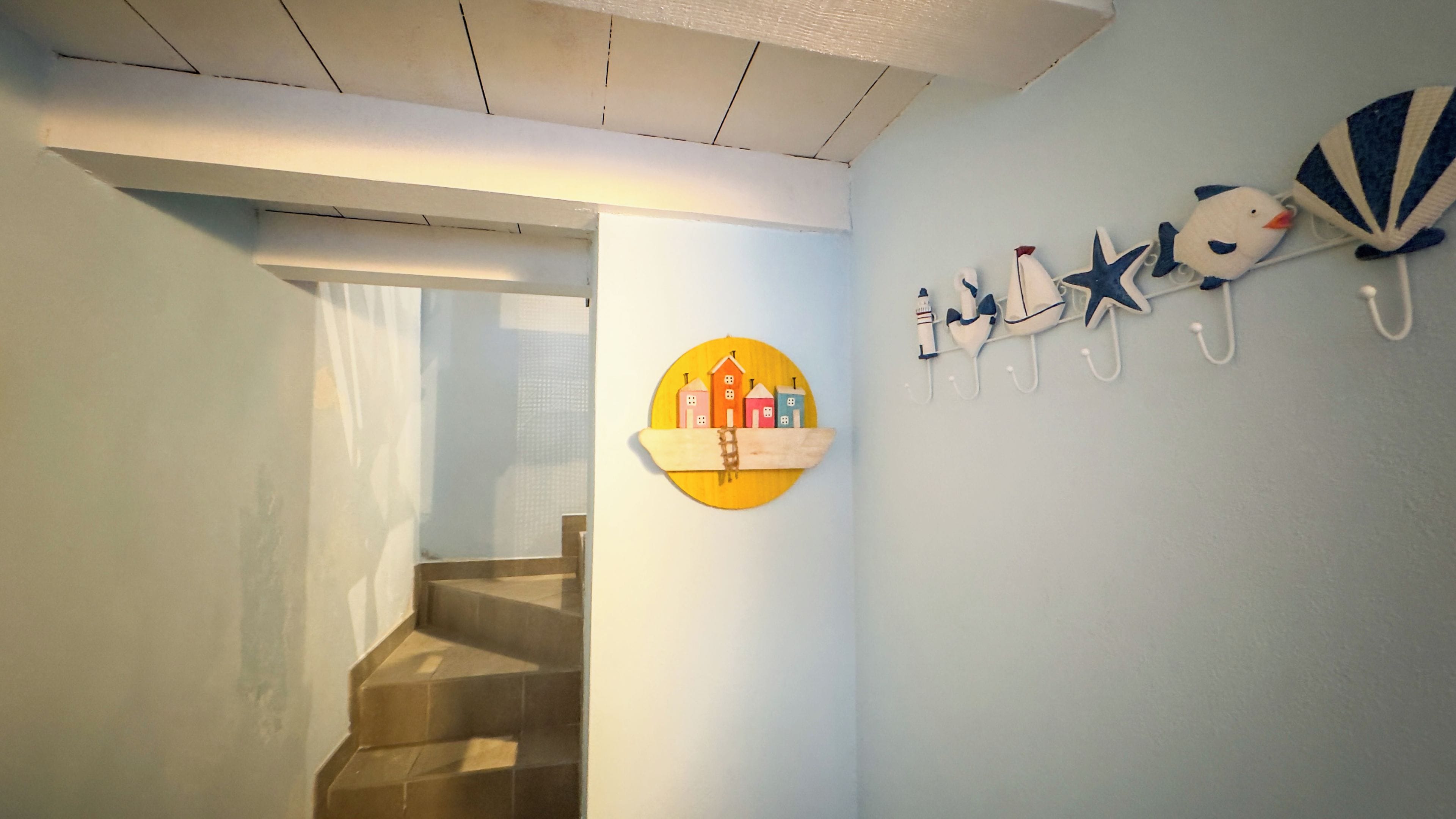 A staircase leading to a landing with a wall-mounted decorative piece featuring buildings and a star.