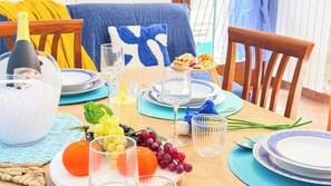 Mesa posta com pratos, copos, garrafa e frutas.