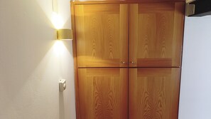 Un armario de madera con una lámpara sobre él.