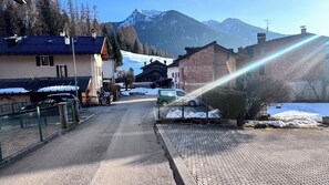 Una calle con edificios, una furgoneta estacionada y nieve en el suelo.
