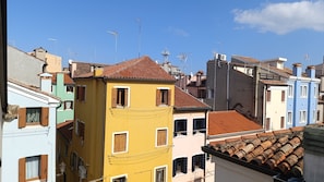 Una hilera de edificios coloridos con techos de tejas rojas y varias antenas.