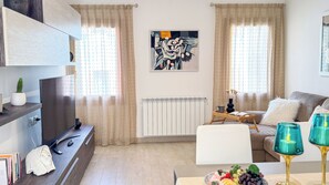 Una sala de estar moderna con un sofá, una mesa de centro, un televisor y un radiador.