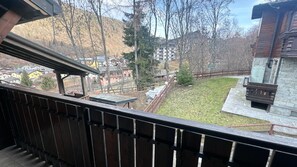 A balcony with a view of a residential area, including houses and a small park. - Coccola Alpina by Ca-sa Check (Aprica)