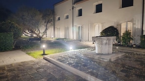 A courtyard with a stone bench, a planter, and a building with multiple windows. - Casa Anna by Ca-sa Check (Venice)