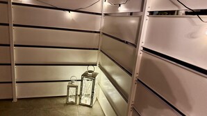 Um depósito com estantes de metal, piso de azulejos e duas lanternas iluminadas.