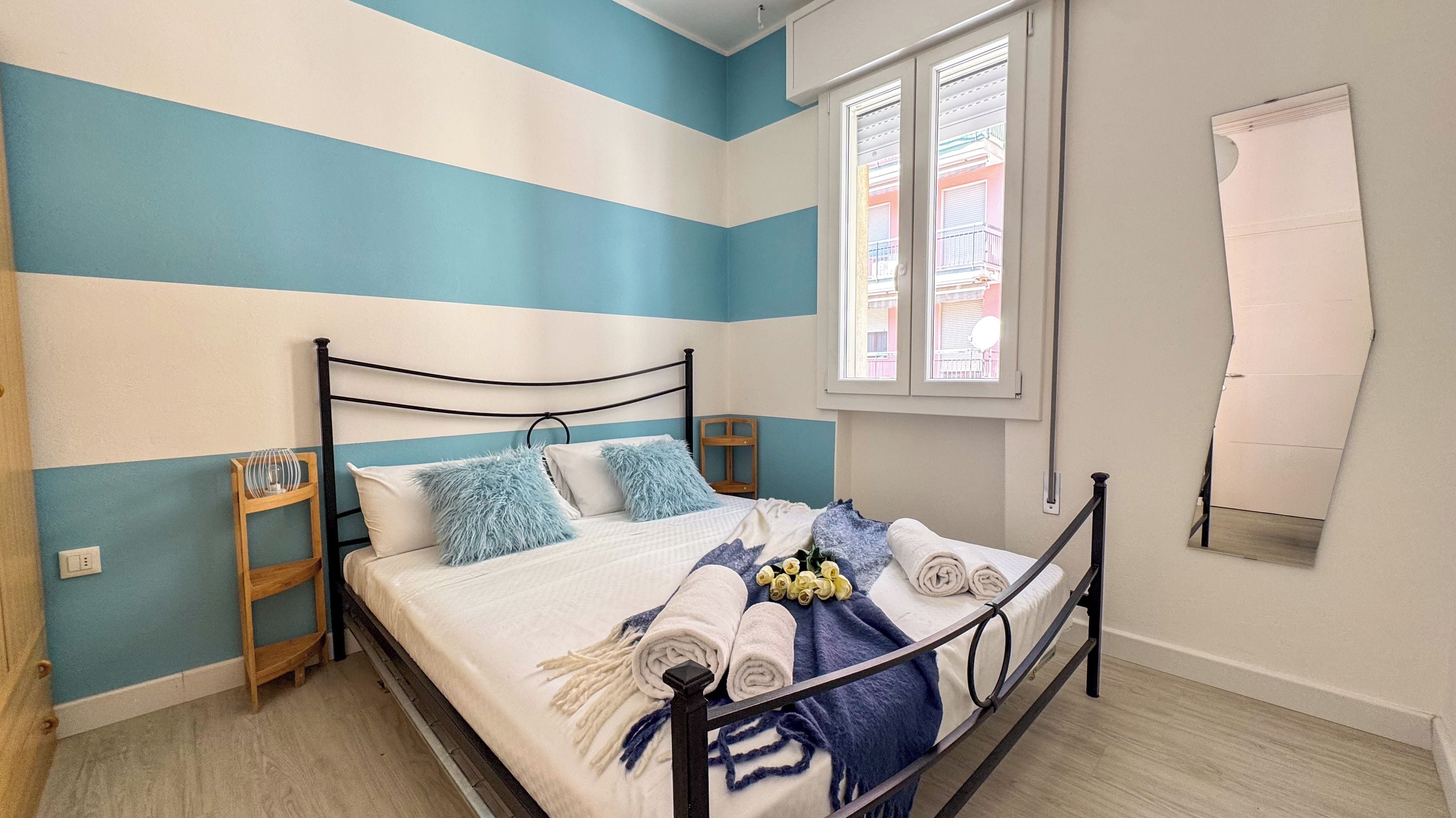 Ein Schlafzimmer mit einem Bett, einem Fenster und einem an der Wand befestigten Gegenstand.