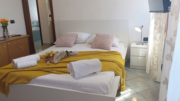 A hotel room with a bed, pillows, a bedside lamp, and a nightstand. - Mi Casa Es Tu Casa by Ca-sa Check (Chioggia)