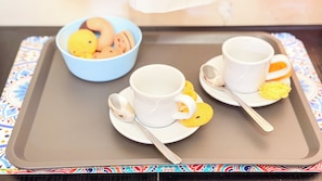 A tray with two white cups and spoons, a bowl of cookies, and a colorful border. - Code Zero Apartment by Ca-sa Check (Chioggia)