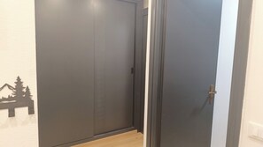 Un pasillo con una puerta cerrada y un muro con silueta de montaña.