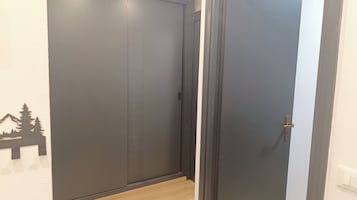 Um corredor com uma porta fechada e uma parede com o contorno de uma montanha.
