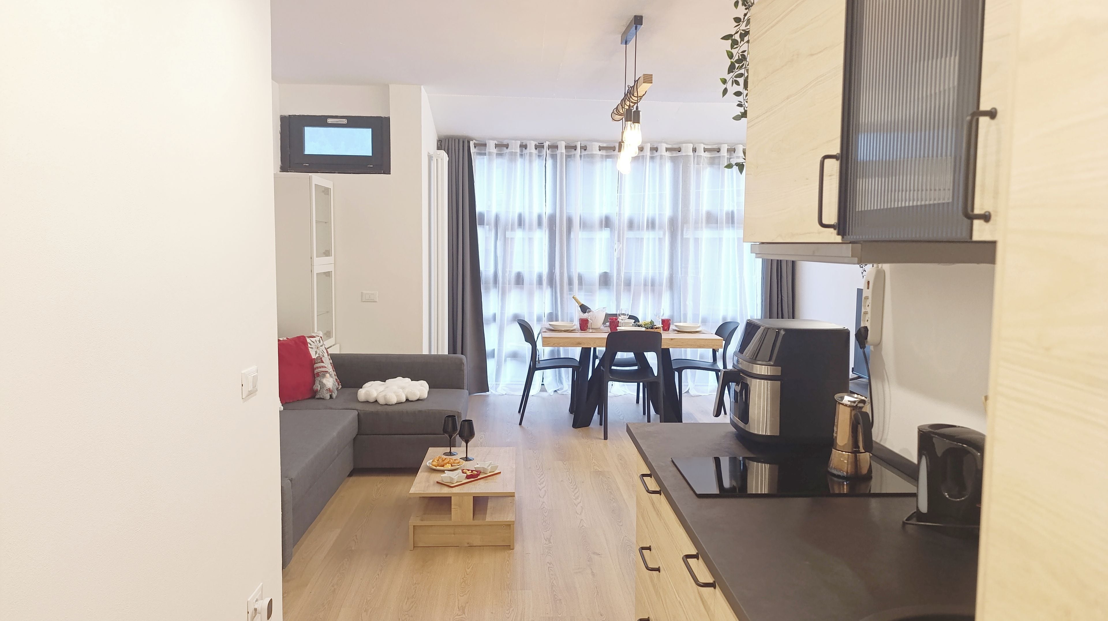 A compact living space with a sofa, dining table, and kitchenette.