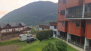 Zona residencial com edifícios modernos, uma caravana e montanhas ao fundo.