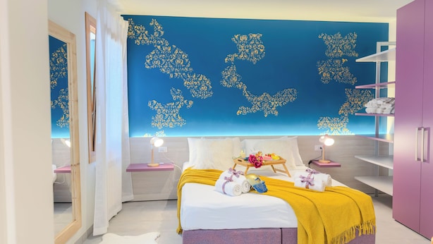 A bedroom with a bed, bedside tables, a wardrobe, and a wall with decorative patterns. - Velvet Suite by Ca-sa Check (Chioggia)