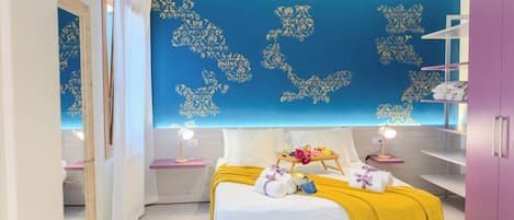 A bedroom with a bed, bedside tables, a wardrobe, and a wall with decorative patterns.