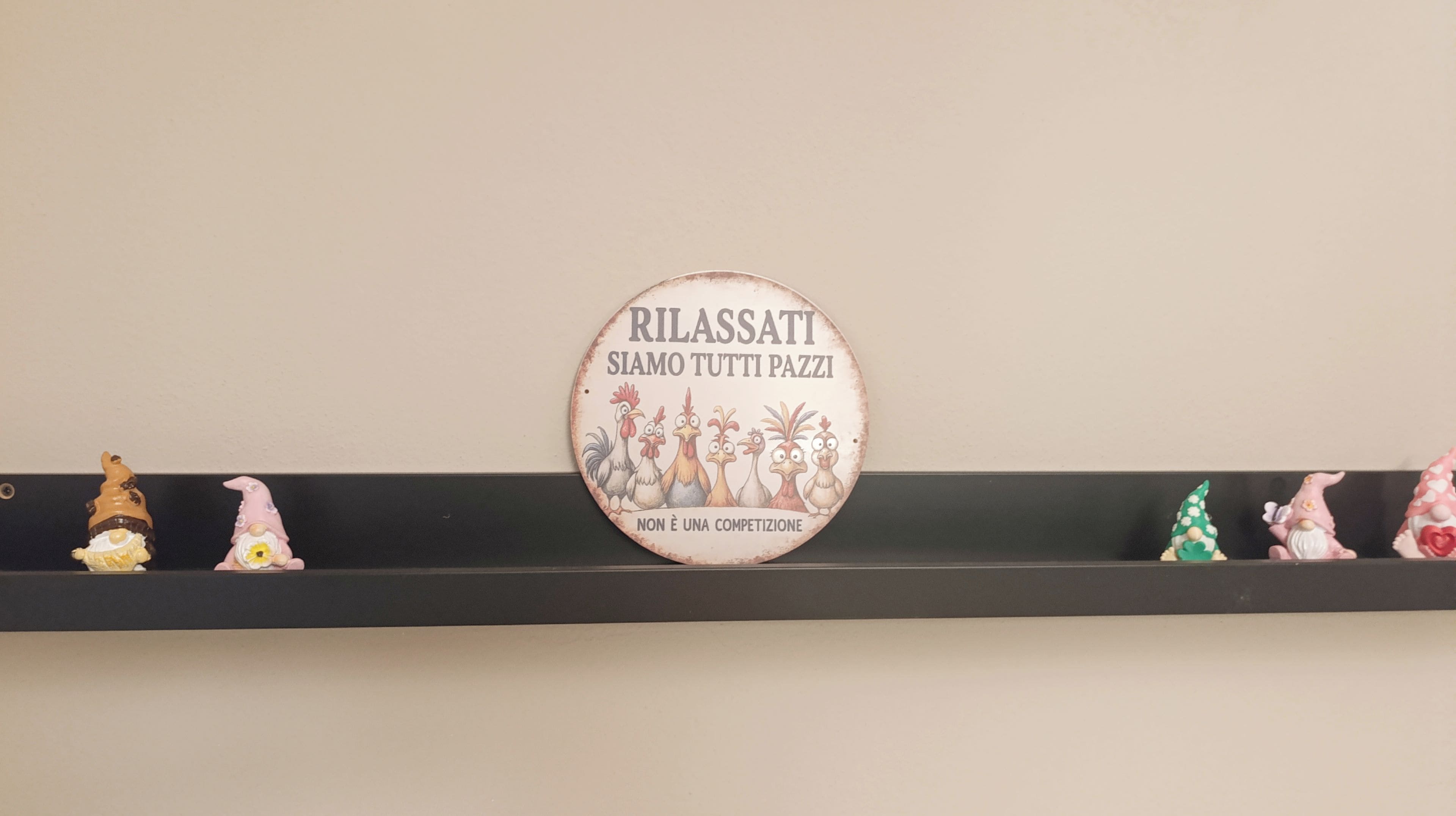 A wall with a circular sign and a shelf with figurines.