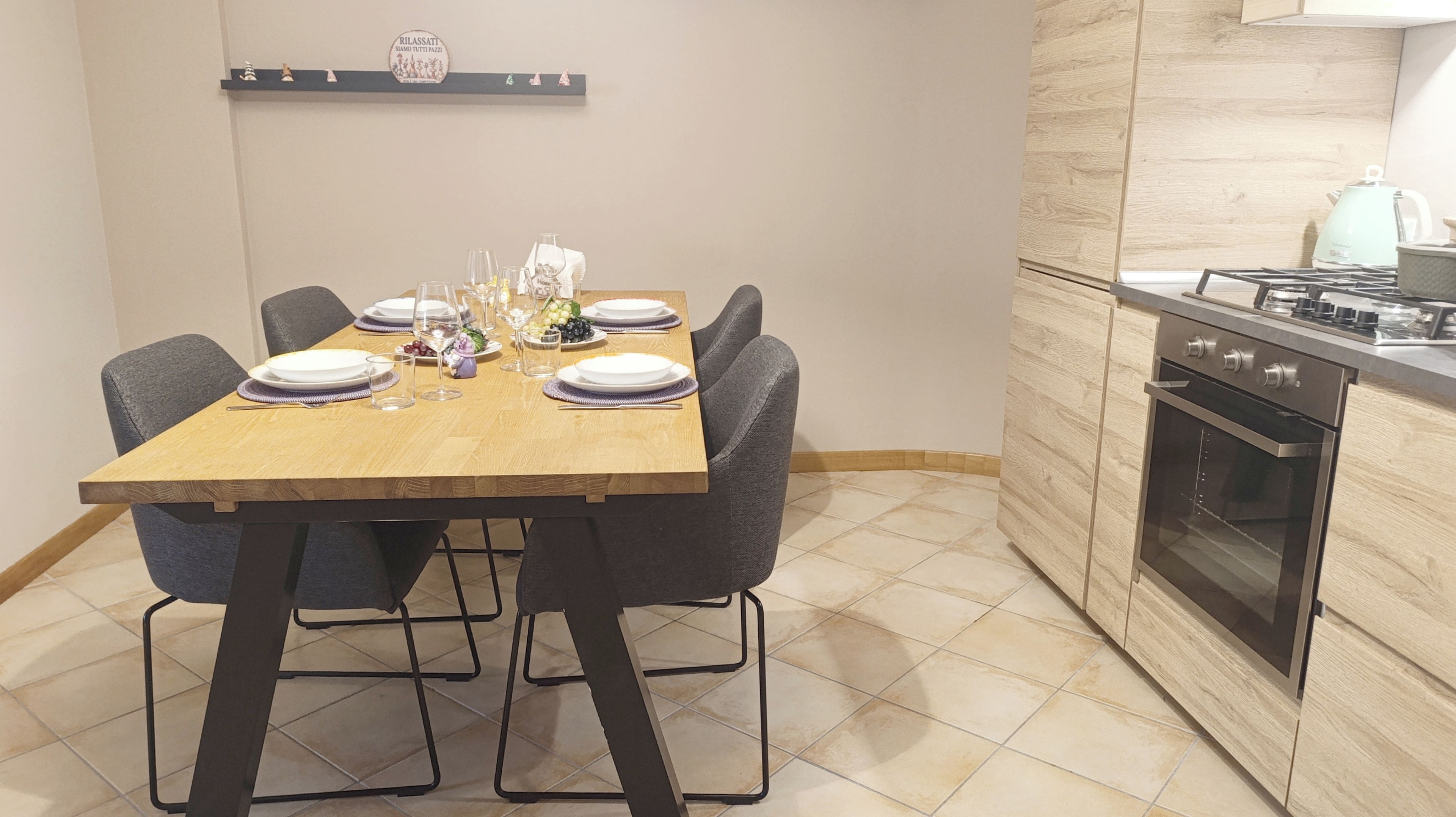 A dining area with a wooden table set for six, surrounded by chairs.
