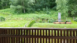 Um deck de madeira com vista para um jardim cercado.