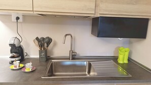 A kitchen with a stainless steel sink, a coffee machine, and a utensil holder. - La Casa di Fede By Ca-sa Check (Aprica)