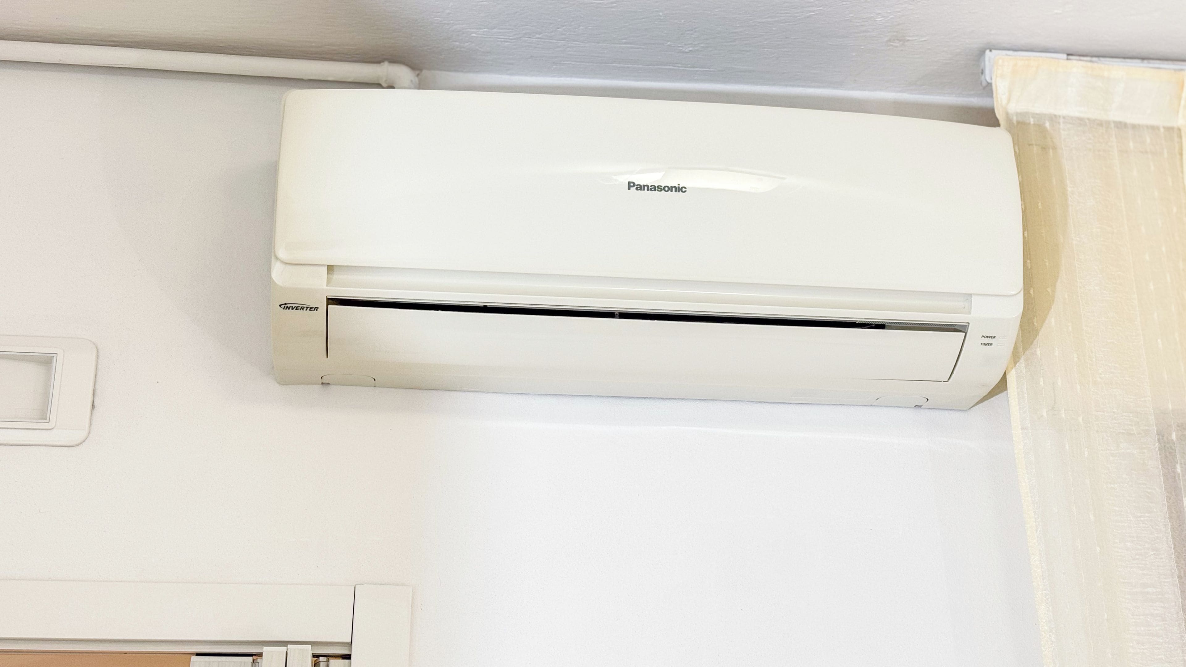 Un aire acondicionado blanco de Panasonic montado en una pared.