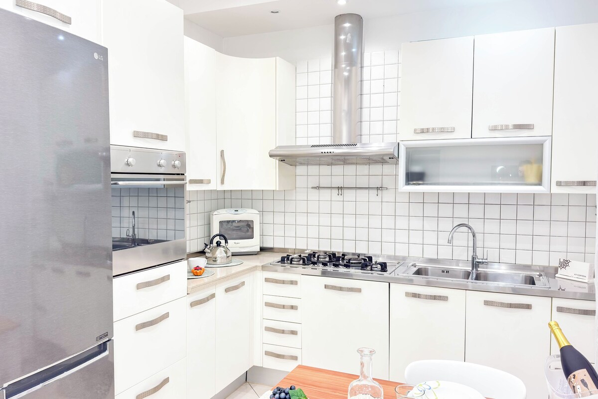 A modern kitchen with a stainless steel refrigerator, built-in oven, microwave, and gas stove.