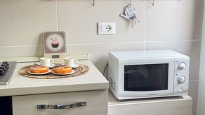 Eine Küche mit Mikrowelle, Toaster und einem Tablett Gebäck.