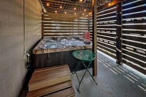 A hot tub area with a wooden bench, a small table, and a metal railing. - Cozy Cove Lodge | Game Room + Private Hot Tub! (Ruidoso)