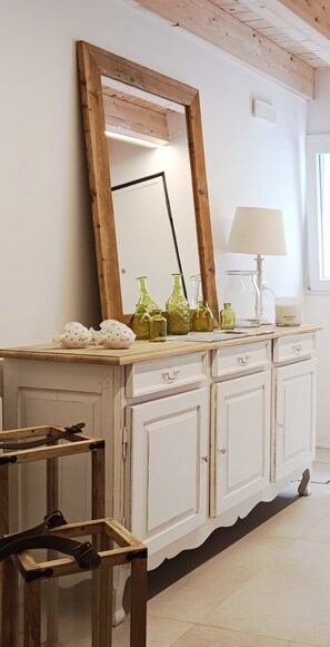 A white wooden cabinet with a mirror, green glass bottles, and a lamp. - Calle Piva, 788 by Ca-sa Check (Chioggia)