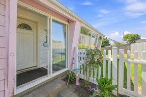 A house with a front door, a window, a white picket fence, and a garden with plants and flowers. - Coastal Cottage Near Yaquina Views, Sleeps 6 (Newport)
