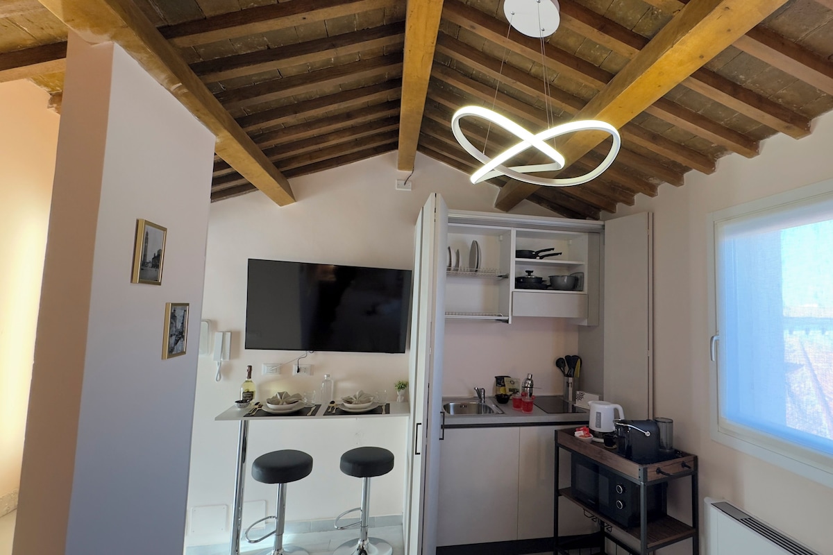 Eine kompakte Küche mit Holzboden, integriertem Fernseher und Fenster mit Blick.