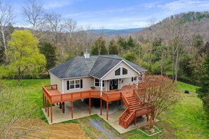 A two-story house with a deck and a staircase leading to the second floor. - "TreeHouse" | Hot Tub | River Access | 20m to SNP (Front Royal)