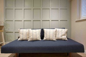 Un letto con un materasso blu scuro e due cuscini a righe.