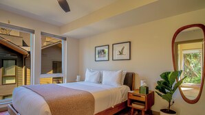 A bedroom with a large bed, a nightstand, a mirror, and two framed pictures on the wall. - River Street Lookout - Lux 3BD w/ Rooftop Views + Hot tub - Downtown Hailey (Hailey)
