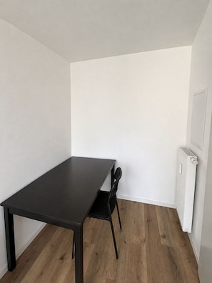Een kamer met een donkerhouten tafel en een zwarte stoel.