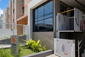 Un edificio moderno con fachada de vidrio, un letrero que dice 'smart' y una estructura metálica con detalles en rojo y negro.