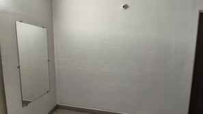 A room with a large mirror on one wall and a plain white wall on the other. - Shrikrushna The Lakeview Resort  (Jalgaon)