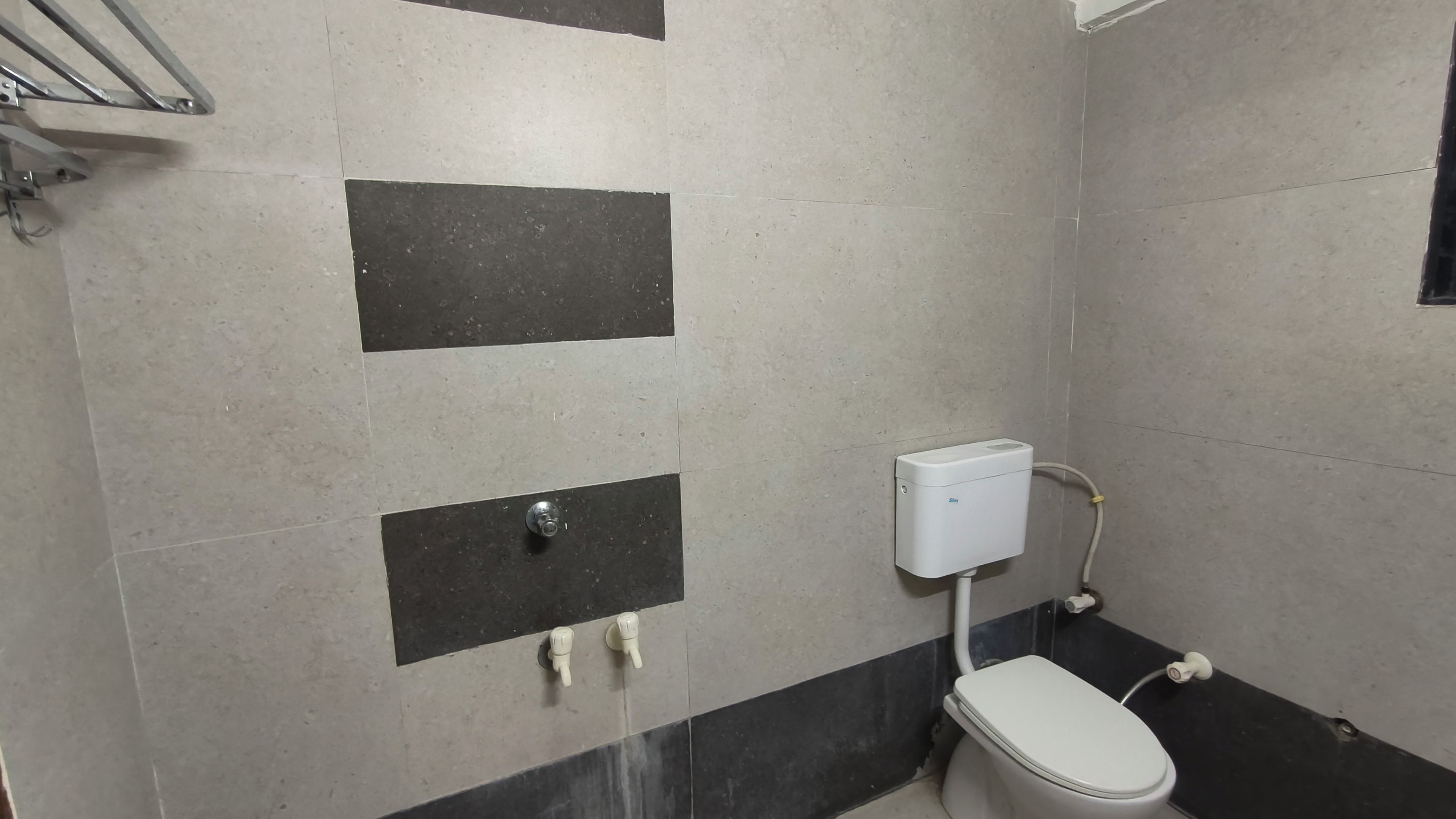 A small bathroom with a toilet, a hand dryer, and a wall-mounted sink.