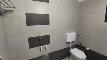 A small bathroom with a toilet, a hand dryer, and a wall-mounted sink.