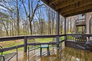 A covered outdoor area with a wooden deck, metal chairs, and a barbecue grill. - Cozy and quiet 2 bedroom condo at Hidden Valley (Hidden Valley)